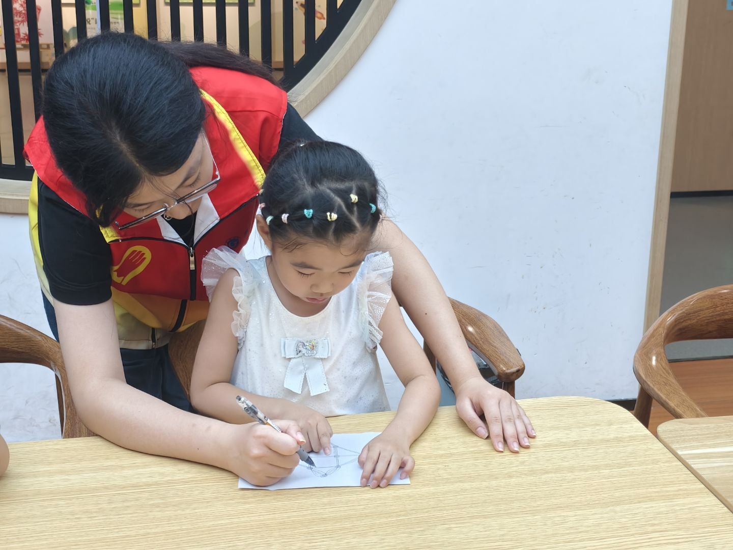 圖為實(shí)踐隊(duì)員輔助孩童共同完成一筆畫圖形。方彥 供圖